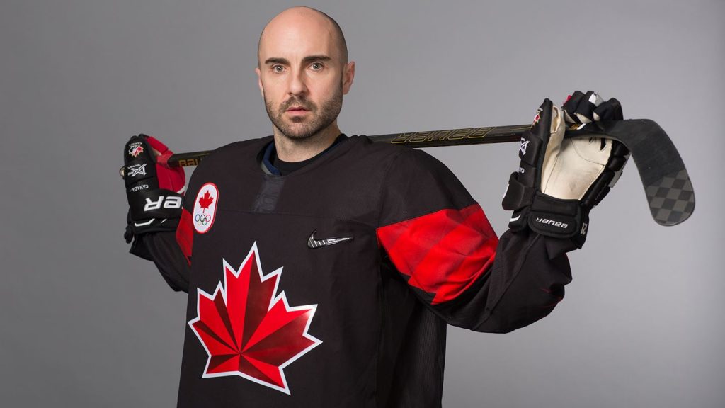 2020 Inductee Chris Lee in his 2018 Team Canada Olympic hockey jersey in front of a grey background.